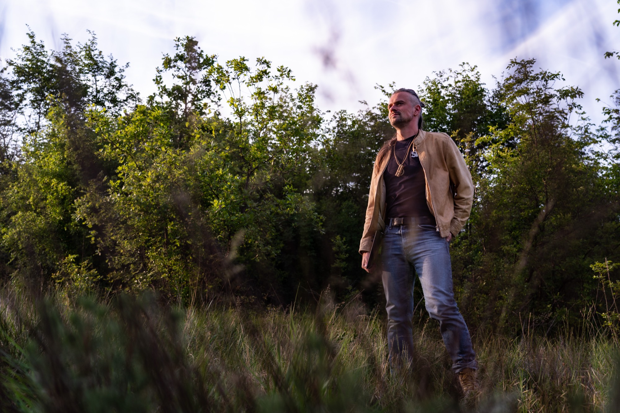Axel Wild standing in a field at the edge of the woods, holding his Circuit Rhythm